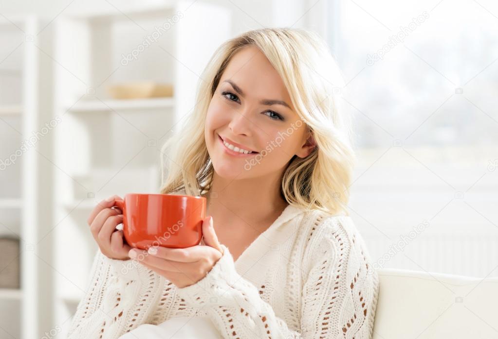 Attractive smiling girl enjoying the smell of coffee in the morning