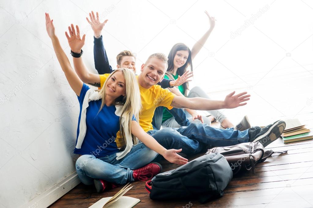 Group of happy students on a break waving
