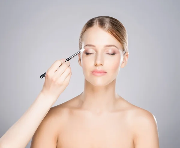 Beautiful girl is being applied with cosmetics — Stock Photo, Image