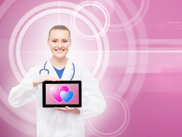 Médico feliz com um tablet e corações nele — Fotografia de Stock