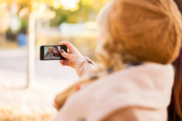 Dos chicas tomando selfies en el parque de otoño —  Fotos de Stock