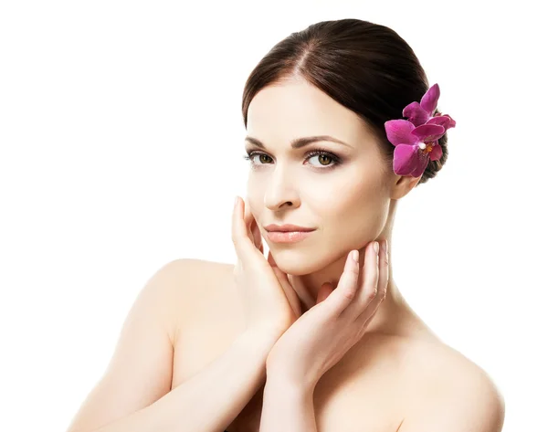 Close-up portrait of young, beautiful and healthy woman with an orchid flower in her hair — Stock Photo, Image