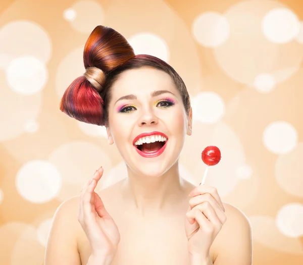 Mooie lachende vrouw met een lolly op bubbly achtergrond — Stockfoto