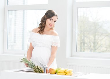 pregnant woman washing pineapple clipart