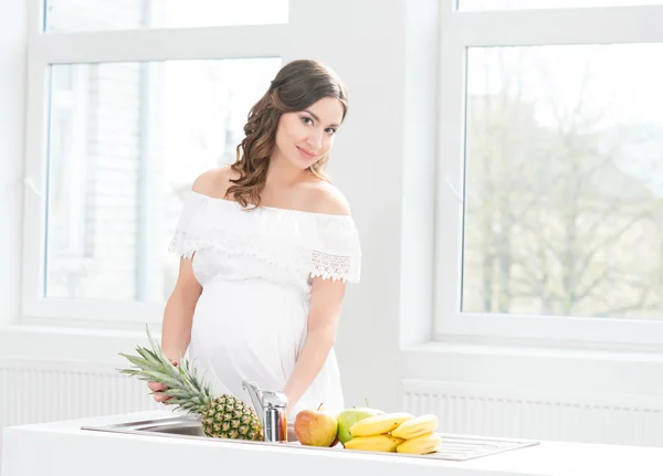 Pregnant woman washing pineapple — Stock Photo, Image