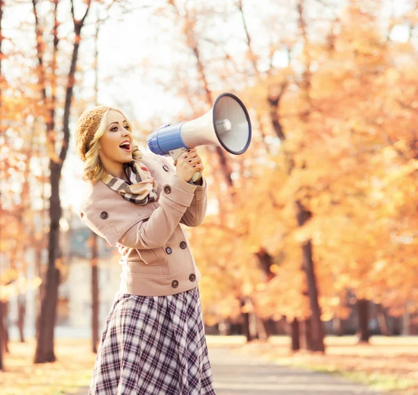 Femme criant avec haut-parleur dans le parc d'automne — Photo