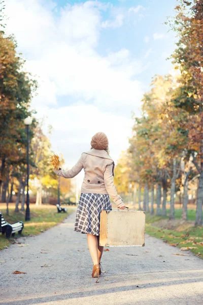 Женщина наслаждается прогулкой в осеннем парке — стоковое фото