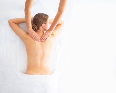 Beyaz arka planda masaj yaptıran genç bir kadın. Spa, sağlık ve dinlenme konsepti.