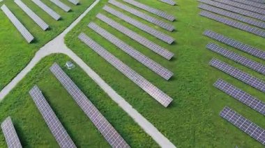 Estonya 'nın Paldiski yakınlarındaki yenilenebilir bir enerji santralindeki rüzgar türbinlerinin ve güneş panellerinin hava aracı görüntüleri. Videoda sürdürülebilir enerji üretimi, temiz enerji altyapısı ve modern yeşil teknolojinin birleştirilmesi yer alıyor.