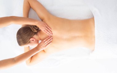Beyaz arka planda masaj yaptıran genç bir kadın. Spa, sağlık ve dinlenme konsepti.
