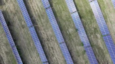 Estonya 'nın Paldiski yakınlarındaki yenilenebilir bir enerji santralindeki rüzgar türbinlerinin ve güneş panellerinin hava aracı görüntüleri. Videoda sürdürülebilir enerji üretimi, temiz enerji altyapısı ve modern yeşil teknolojinin birleştirilmesi yer alıyor.