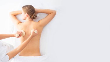 Beyaz arka planda masaj yaptıran genç bir kadın. Spa, sağlık ve dinlenme konsepti.