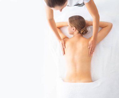 Beyaz arka planda masaj yaptıran genç bir kadın. Spa, sağlık ve dinlenme konsepti.