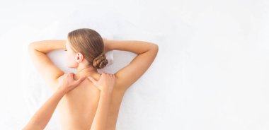 Beyaz arka planda masaj yaptıran genç bir kadın. Spa, sağlık ve dinlenme konsepti.