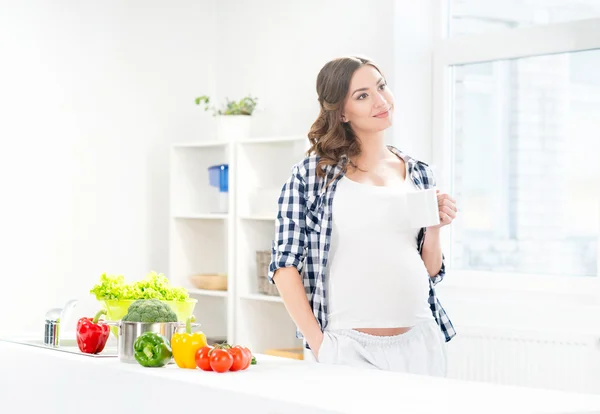 Zwangere vrouw met een kopje koffie — Stockfoto