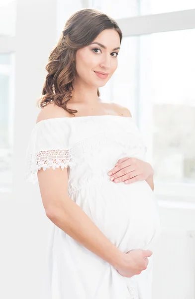 Zwangere vrouw omarmen haar buik. — Stockfoto