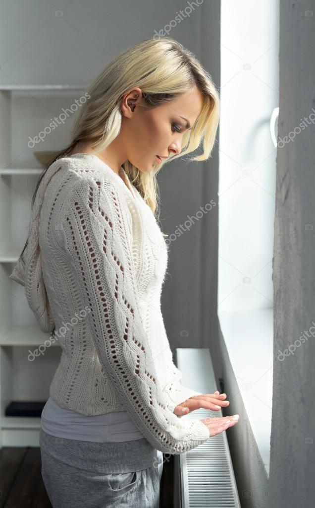 blond woman touching the radiator