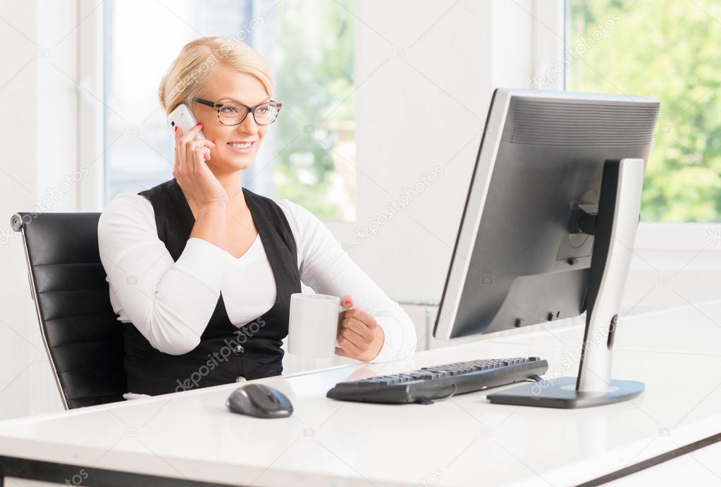 businesswoman talking by the smartphone and drinking coffee