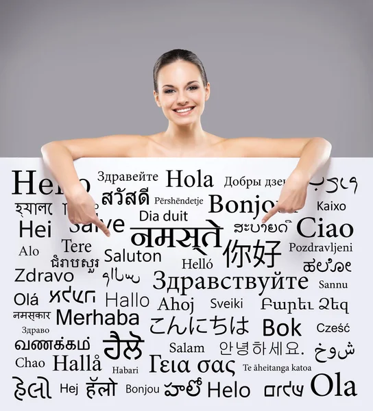 Όμορφη χαμογελαστό κορίτσι με μια πινακίδα διαφορετικές γλώσσες του κόσμου — Φωτογραφία Αρχείου