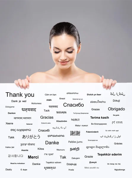 Gyönyörű lány, egy banner, a világ különböző nyelveken — Stock Fotó