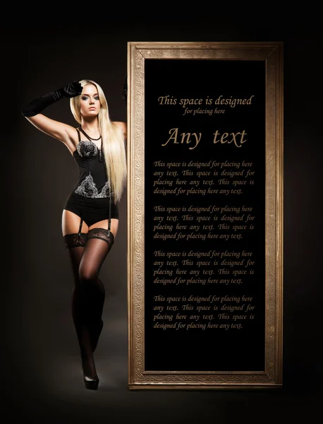 Junge blonde Frau in erotischen Dessous neben einem Rahmen — Stockfoto