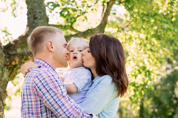 Happy family hugging in a park — Stock Photo, Image