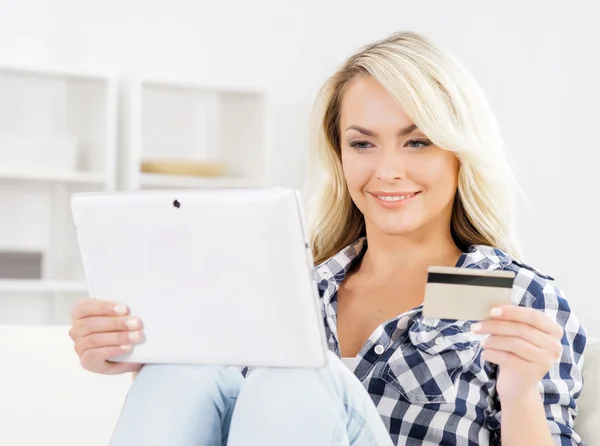 Attractive blond woman with a credit card and a tablet computer — Stock Photo, Image