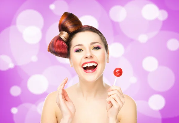 Mooie lachende vrouw met een lolly op bubbly achtergrond — Stockfoto