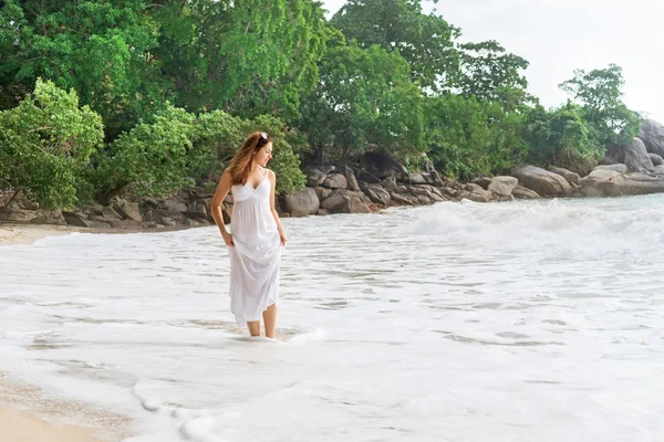 매력적이 고 젊은 여자는 해안 산책과 드레스를 잡아 당겨 — 스톡 사진