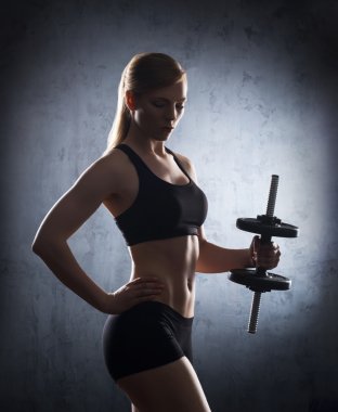 Genç ve formda kadın dumbbells ile