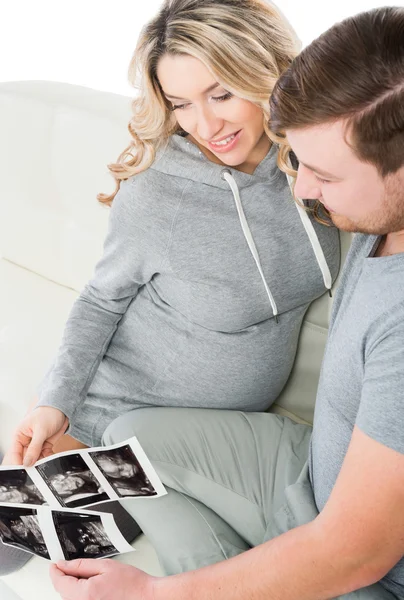 Ung glad familj håller ultraljudsundersökningar — Stockfoto