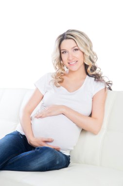 Karnı kucaklayan güzel hamile sarışın