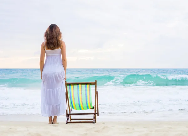 Mujer joven en un vestido en la playa — Foto de Stock