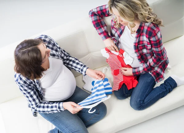 Två unga gravida kvinnor på en soffa — Stockfoto