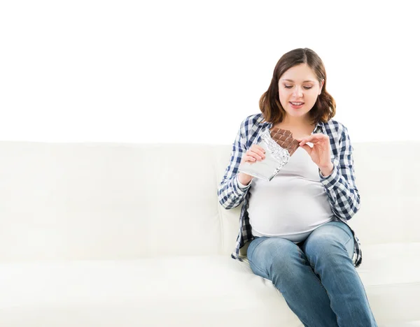 Junge schwangere Frau isst eine Schokolade — Stockfoto