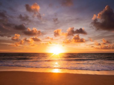 Denizin üzerinde güzel bir gün batımı ve kumsalda yansıması.