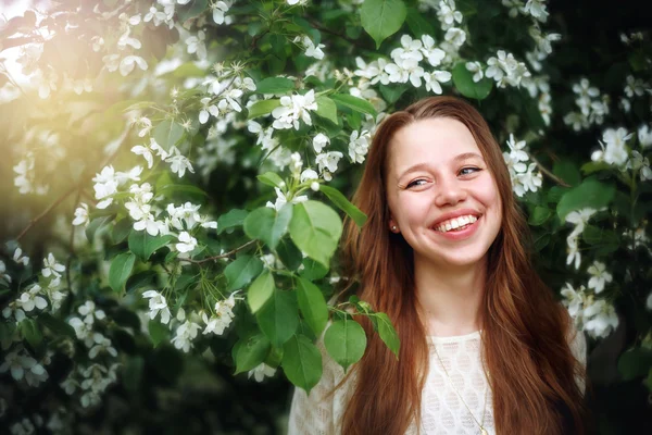 Mulher entre as flores da primavera na natureza — Fotografia de Stock