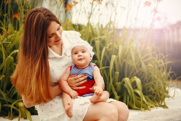 Cute Happy Toddler Sitting on Loving Mother`s Knees 