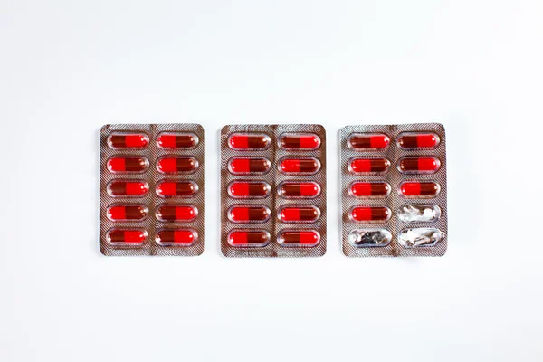 Fila de embalagens com comprimidos ou cápsulas vermelhas — Fotografia de Stock