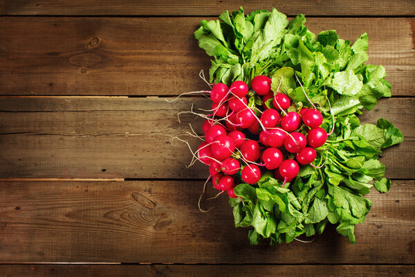 Свежая редька на деревенском деревянном фоне
