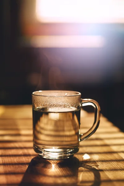 Tasse transparente avec eau chaude sur la cuisine — Photo