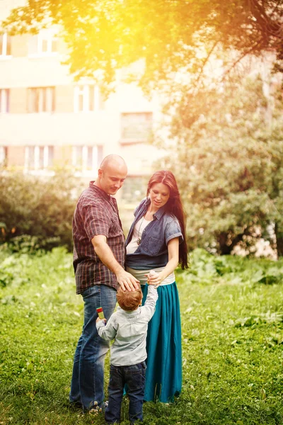 Corps complet de la famille heureuse dans le parc de la ville au coucher du soleil — Photo