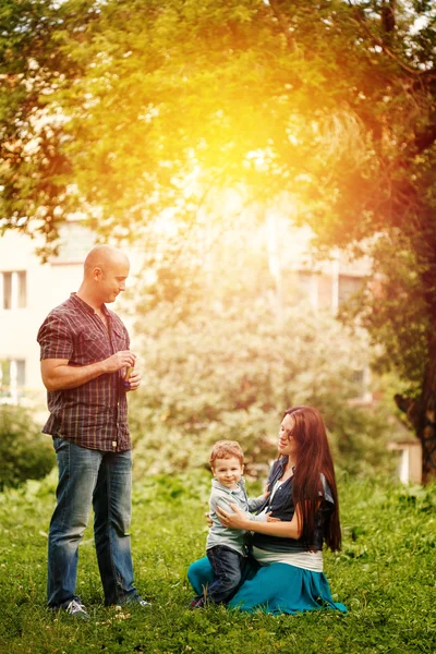 Hele lichaam van gelukkige familie in stadspark bij de zonsondergang — Stockfoto