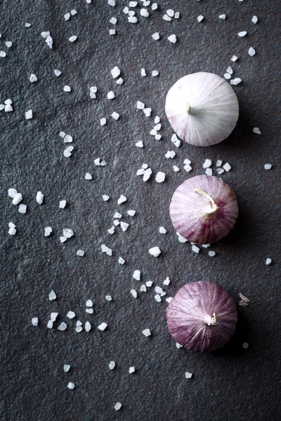 Food background with garlic on dark stone — Stock Photo, Image