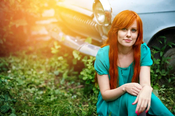 Brilhante jovem mulher posando perto de idade carro — Fotografia de Stock