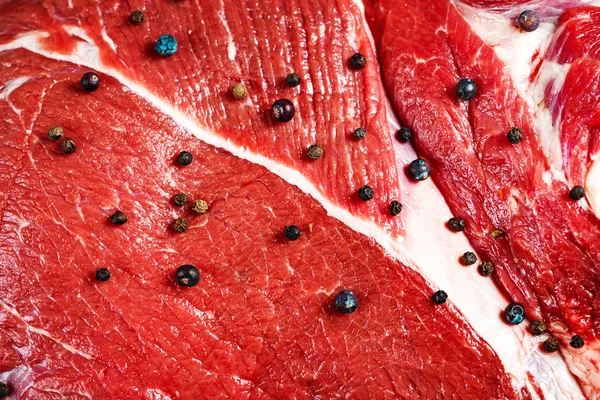 Primo piano di carne di manzo rossa con pepe nero — Foto Stock