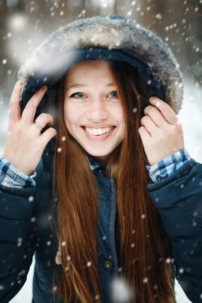 Jovem mulher em roupas de inverno em pé sob a neve — Fotografia de Stock