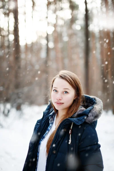 Jovem mulher em roupas de inverno em pé sob a neve — Fotografia de Stock