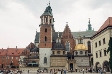 KRAKOW, POLAND - 21 Temmuz 2019: Ana Katolik Katedrali ve Wawel şatosu ikametgahı kuleleri, gezen ve gezen turistler 