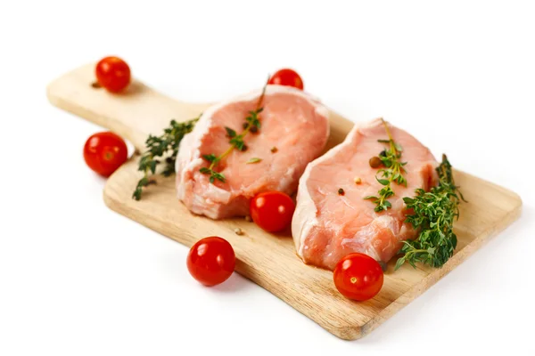 Fresh raw pork steaks on cutting board — Stock Photo, Image